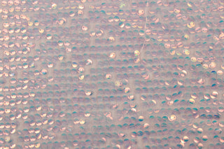 Sequined in Mermaid Scales adds a touch of glamour to any project.&nbsp; Made from a semi-sheer polyester tulle base, it is lightweight and comfortable to wear. The sequins create a stunning pink glimmer that will catch everyone's eye.&nbsp; Perfect for adding sparkle to special occasion apparel, dancewear, costumes, overlays, table tops, and decorations.&nbsp;