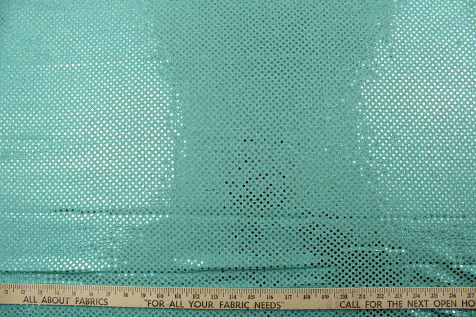 This semi-transparent tulle fabric is adorned with shimmering sequins, creating a beautiful and eye-catching effect in a vibrant aqua color.  Perfect for special occasion apparel, dancewear, costumes, overlays, table tops, and decorations. 