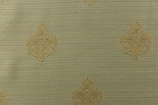 This elegant jacquard fabric features a woven ornamental damask medallion with hints of champagne or light gold on a pale green background. 