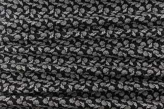  This fabric features a whimsical floral design in white on a black background.
