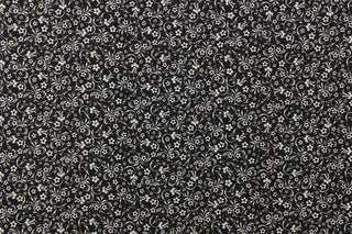 A basic quilting design that everyone will want. This fabric features a dainty floral design in white on a black background.