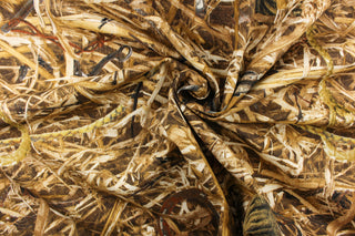 This fabric features a straw camouflage design in brown tones with items within the straw.