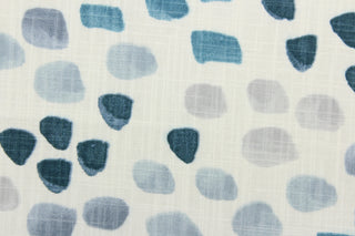 This fabric features a spot design in varying shades of blue and gray against white .