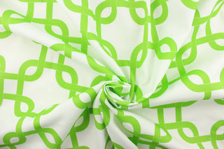 This outdoor fabric features a chain link design in bright green against a white background .