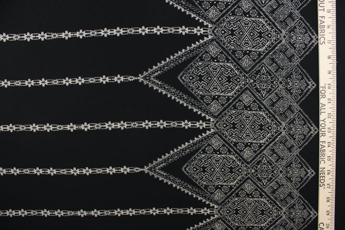 This georgette fabric features an Aztec design in pale beige against black. 