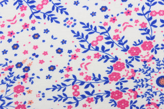 This lycra jersey blend fabric features a floral design in blue, pink, white, and orange.