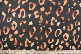 This chiffon fabric features a leopard design in a faded out orange against black. 