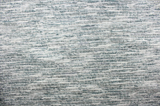 This chenille fabric features a unique design in gray, silver, blue, teal, blue green, and white.