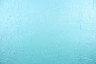 This taffeta fabric features a crinkle in iridescent in a light turquoise blue.