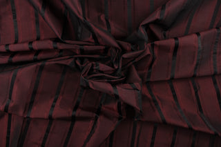 This stunning yarn dyed fabric features a striped pattern in a deep wine and black .