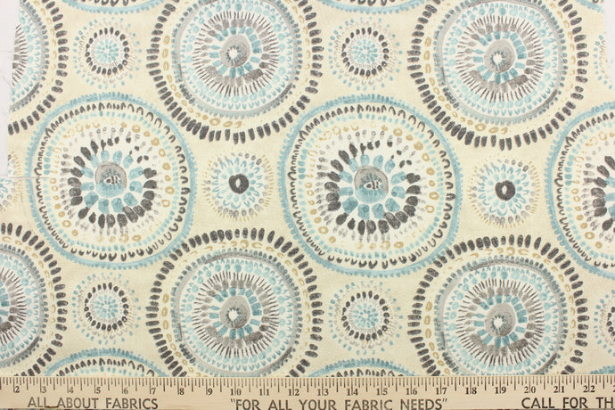 This fabric features a circular or medallion design in gray, blue, beige, white and off white .