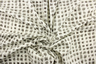 This fabric features a geometric design of small blots in gray against a white background.