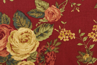 This fabric features a floral design in rose pink, burgundy, green, golden tan, beige, and hunter green against a deep red. 