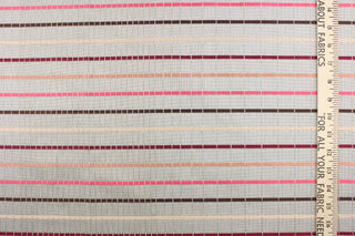 This sheer fabric features a stripe design in a mauve, pink, nude, brown, and burgundy against a silver . 