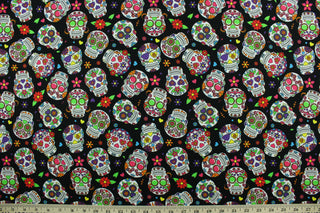 This cotton print fabric features white sugar skulls with bright colored floral detail.  Colors include black, white, blue, yellow, orange, purple, hot pink and green.  It has a nice soft hand and would be great for quilting, crafting and home décor.  