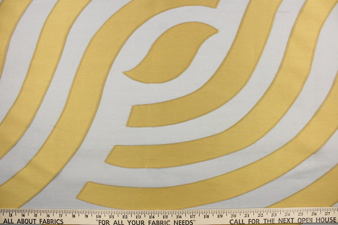 This sheer fabric features a curved line design  in a gold and black . 