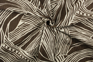 This fabric features an oversized leaf design in brown and off white 