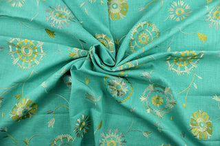 Suzani features an embroidered ethnic design in shades of green and gold against an aqua background.  Uses include drapery, pillows, light upholstery, table runners, bedding, headboards, and home décor.