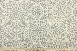 This fabric features a medallion design in gray and pale beige with hints of white. 