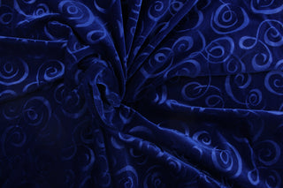 A velvet featuring a swirl design in a tone on tone rich dark blue .