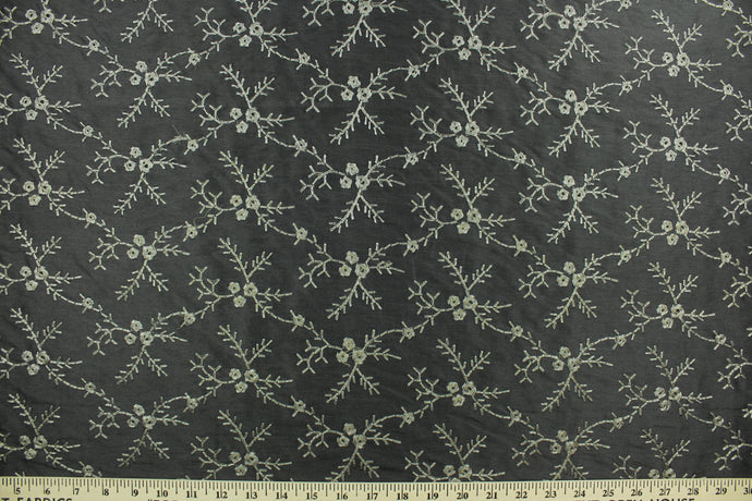 Midnight Snowfall features an embroidered floral vine in pewter set against a black background.  The embroidered design adds an elegant look to the fabric.  Uses include apparel, decorative pillows, window treatments and bedding.