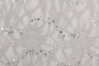 This lace features a floral sequin design in a silver or gray with a stretch. 