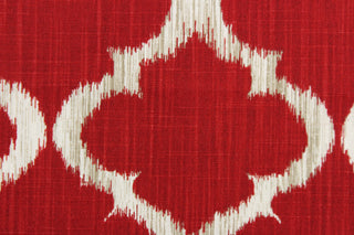 This fabric features a geometric design in rich red, white, and taupe .