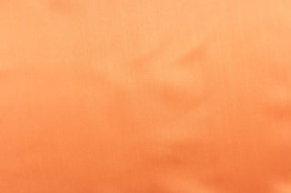  A beautiful satin fabric in a orange  color.