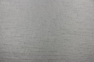  Voltaire is a woven, textured fabric in silver grey.  It has a slub yarn running across the the fabric which creates the look of silk with a soft, drapable hand.  The weight is suited for draperies, light upholstery, headboards, decorative pillows, coverlets and cornice boards.  We offer Voltaire in several different colors.