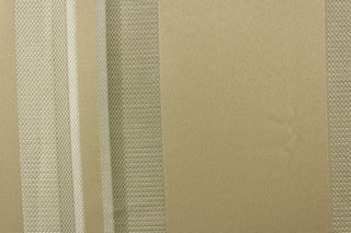  This rich woven yarn dyed fabric features bold multi width striped pattern in shades of champagne on a khaki or beige background. 