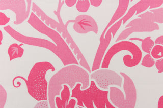 This fabric features a  large floral vine design with  colors in varying shades of pink flowers on a white background. 