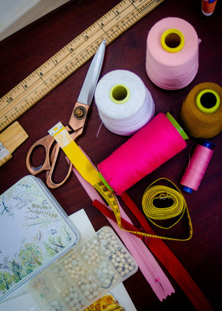 Sewing supplies like thread, ruler, scissors, and pins