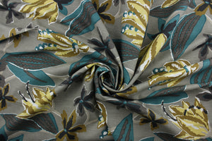 The exciting floral print features a palette of yellow, dark gold, teal, black and white on a grey background.  The multi-purpose fabric is soil and stain resistant and has been tested to withstand up to 65,000 double rubs for added durability.  It can be used for several different statement projects including window accents (drapery, curtains and swags), toss pillows, headboards, bed skirts, duvet covers and upholstery. 