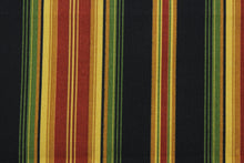 Load image into Gallery viewer, This Richloom© Lyndhurst in Raven multipurpose outdoor fabric adds a unique style to any space, featuring stripes of green, black, yellow, brick red, and goldenrod.  Durable and long-lasting, it is rated for 10,000 double rubs.  Can withstand up to 500 hours of direct sunlight, it is also water and stain resistant.  Perfect for patio, deck and poolside.  It can be used for several different statement projects including cushions, upholstery projects and decorative pillows. 
