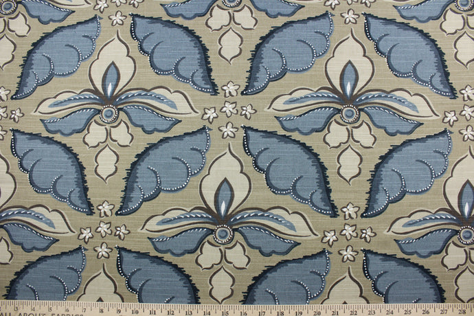 Showcasing a large floral print in the colors of indigo, white, brown, and tan this multipurpose fabric features a camel brown background for lasting appeal. Certified with 30,000 double rubs and treated with a soil and stain repellant finish, this fabric is perfect for bringing your interior design ideas to life.  It can be used for several different statement projects including window accents (drapery, curtains and swags), toss pillows, headboards, bed skirts, duvet covers, upholstery, and more.