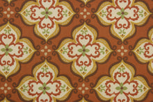 Load image into Gallery viewer, Robert Allen© Suri in India is a multipurpose indoor/outdoor fabric featuring an intricate medallion print in shades of brown, green, dark yellow, cream, and set on a teracotta background.  This fabric is U/V fade and water/stain repellant.  Perfect for porches, patios and pool side.  Uses include toss pillows, cushions, upholstery, tote bags and more. 

