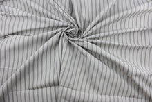 Load image into Gallery viewer, Robert Allen© Dateline is a versatile fabric with a horizontally vertically striped pattern.  Combining sterling gray with a crisp white hue, this luxurious fabric is perfect for modern décor.  It can be used for several different statement projects including window accents (drapery, curtains and swags), toss pillows, headboards, bed skirts, duvet covers, upholstery, and more.
