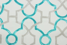 Load image into Gallery viewer, This printed cotton twill fabric features a geometric design in turquoise and grey on an off white background.  It is perfect for window treatments, decorative pillows, handbags, light duty upholstery applications.  This fabric has a soft workable feel yet is stable and durable with 50,000 double rubs.  
