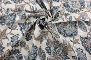  Covington© Foligno in Laguna is a versatile, beautiful fabric with a non-woven backing.  Its Jacobean floral print in shades of blue, aqua, deep gold/bronze, neutrals, and cream adds a touch of elegance to any project.  It can be used for several different statement projects including window accents (drapery, curtains and swags), toss pillows, bed skirts, and duvet covers.  It has a soft workable feel yet is stable and durable with 12,000 double rubs.