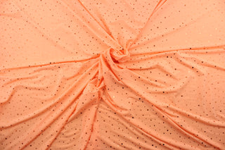 This product features a polyester base accented with shiny, sequined dots in peach.  The polyester material provides durability and the peach color adds a touch of elegance.  Enjoy ultimate comfort and flexibility with its 8 way stretch.  Perfect for adding sparkle to special occasion apparel, dancewear, costumes, overlays, table tops, and decorations. 