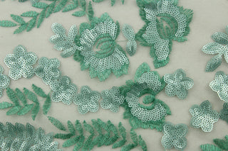 This green sequined net features an embroidered and sequined floral vine and delicate butterflies, adding a touch of elegance to any project.  The varying shades of green bring a natural and refreshing aesthetic.  Made with a tulle base, it is lightweight and easy to work with.   Perfect for adding sparkle to special occasion apparel, dancewear, costumes, overlays, table tops, and decorations. 