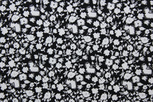 Load image into Gallery viewer, Wildflower features a timeless print of small white wildflowers on a simple black background.  The high-quality cotton material ensures lasting durability and softness, making it perfect for your next quilting or stitching project.  The versatile lightweight fabric is soft and easy to sew.  It would be great for apparel, quilting, crafting and sewing projects.  
