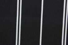 Load image into Gallery viewer, This outdoor fabric features white stripes set against a black background. It has a slightly stiff feel but easy to work with.  Solarium fabric will withstand up to 500 hours of sunlight, resists stains, water resistant and has a rating of 10,000 double rubs.  Perfect for porches, patios, and poolside.  Uses include toss pillows, cushions, upholstery, tote bags and more.
