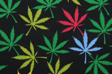 Load image into Gallery viewer,  Reefer in Rainbow offers a vibrant twist on traditional marijuana leaves.  This special fabric features a vibrant array of colors, including shades of green, red, blue, and yellow against a black background.  The high-quality cotton material ensures lasting durability and softness.  It would be great for apparel, quilting, crafting and sewing projects.  
