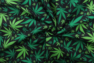  Doobie in Black features a repetitive marijuana leaf pattern in green against a black background. This fashionable design is perfect for expressing yourself in a subtle and stylish way.  The high-quality cotton material ensures lasting durability and softness.  It would be great for apparel, quilting, crafting and sewing projects.  