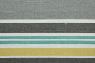 Robert Allen© Mod Layout in Fiesta is a multi-purpose fabric that features multicolored stripes in shades of gray, jade, white, and yellow.  The fabric is treated with a soil and stain repellant finish to ensure long lasting durability, with a rating of 30,000 double rubs.  It can be used for several different statement projects including window accents (drapery, curtains and swags), toss pillows, headboards, bed skirts, duvet covers and upholstery. 