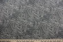 Load image into Gallery viewer, multi-use fabric with a stylish zebra print.  It features an eye-catching combination of charcoal and off white that will bring a modern touch to any room.  This fabric is incredibly durable with 95,000 double rubs of wear, and its soil and stain resistant surface makes it easy to clean and maintain.  It can be used for several different statement projects including window accents (drapery, curtains and swags), toss pillows, headboards, bed skirts, duvet covers, upholstery, and more.
