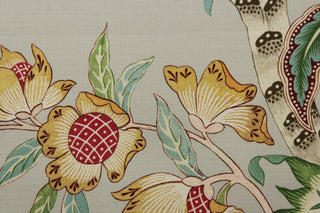 a multipurpose fabric featuring a stunning array of printed floral Jacobean motifs in various shades of blue, green, orange, yellow, beige, taupe, tan, red, and pink. The pale light gray background adds a touch of softness to this durable fabric, which is also soil and stain repellant and boasts a 25,000 double rub rating for long-lasting quality. 