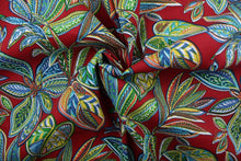 Load image into Gallery viewer, Crestwood is for outdoor use, with a beautiful flowing leaf design featured in shades of blue, green, yellow, orange and white against a red background.  It is UV fade, water and stain resistant, with a durability rating of 15,000 double rubs. Perfect for porches, patios and pool side.  Uses include toss pillows, cushions, upholstery, tote bags and more.  
