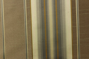 This stunning yarn dyed fabric features a multi width striped pattern in old gold, gray, light khaki against a gray brown. 